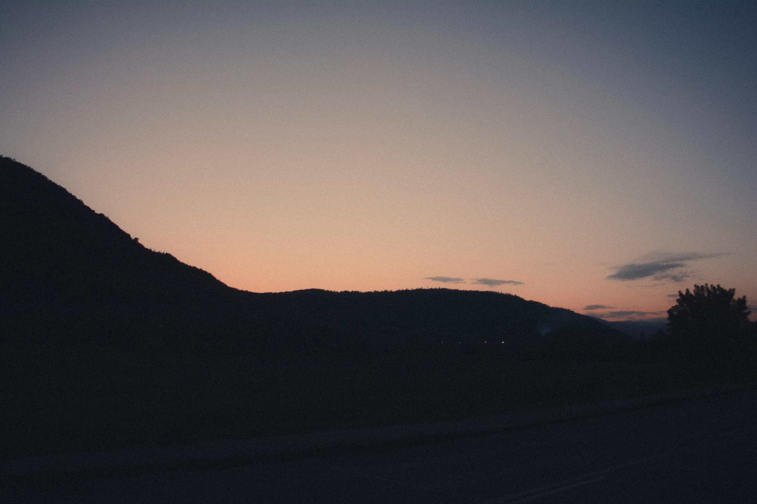 Silhouetted hills and a road at dusk