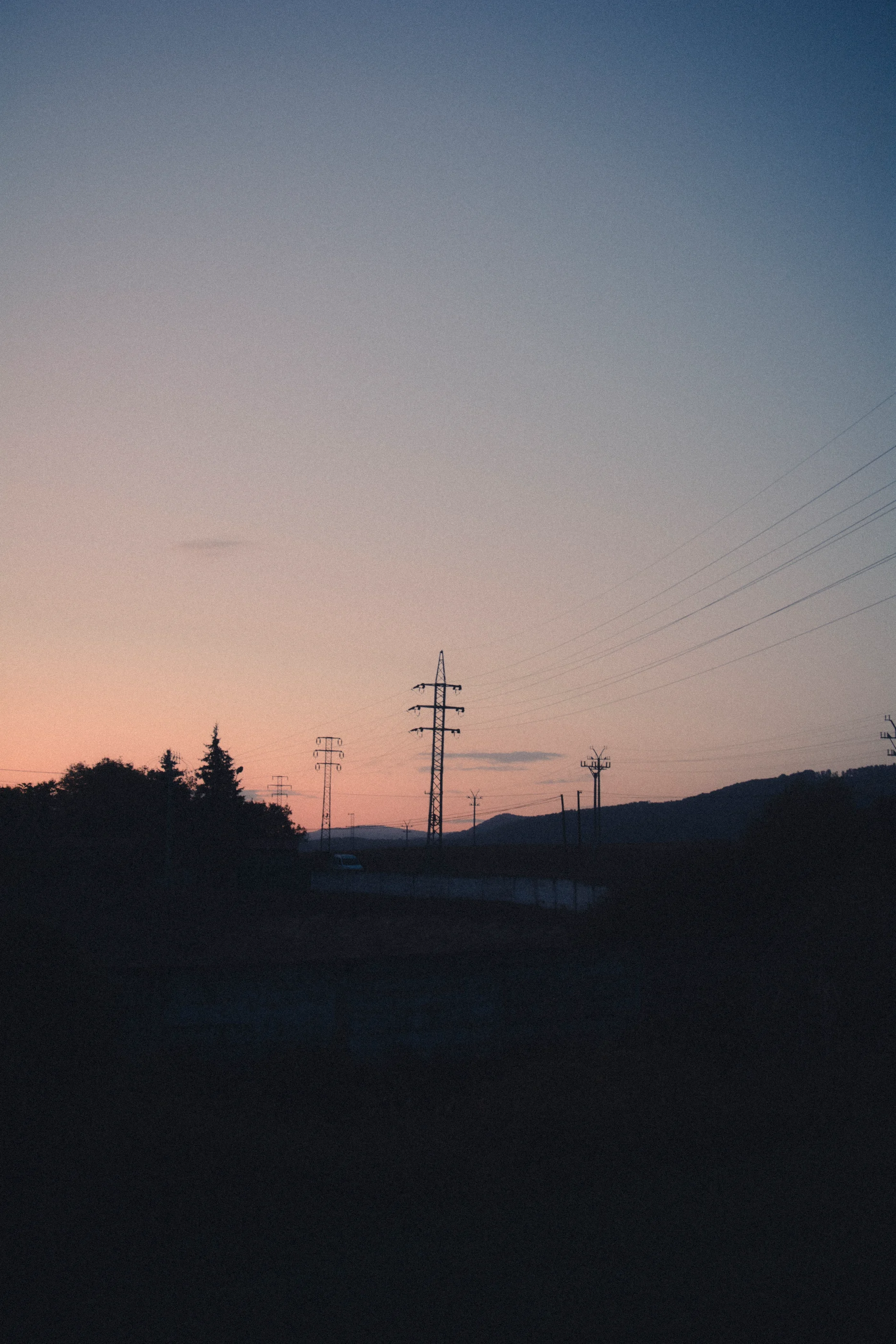 Electricity pylons against a warm evening sky